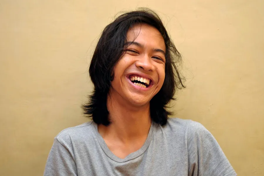 Person wearing a gray T-shirt laughing